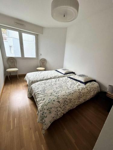 une chambre avec deux lits et deux fenêtres dans l'établissement Résidence Laétitia - LA BAULE - PLAGE ET COMMERCES MAE-9563, à La Baule