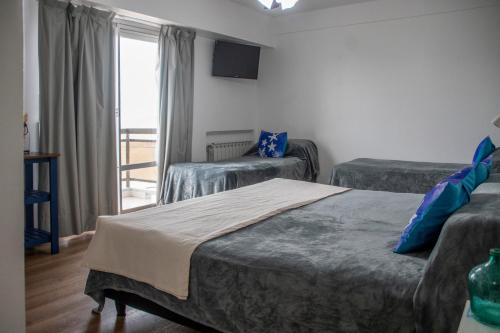 a hotel room with two beds and a balcony at Hotel Solmar in San Clemente del Tuyú