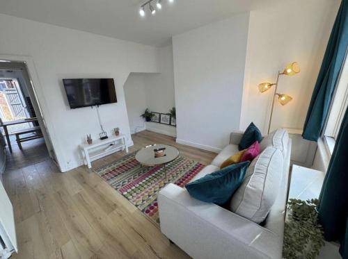 a living room with a couch and a tv at Levenshulme House - 2 Bedroom - Sleeps 6 - Free Parking & WiFi in Manchester