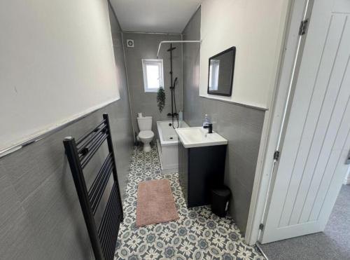 a small bathroom with a sink and a toilet at Levenshulme House - 2 Bedroom - Sleeps 6 - Free Parking & WiFi in Manchester