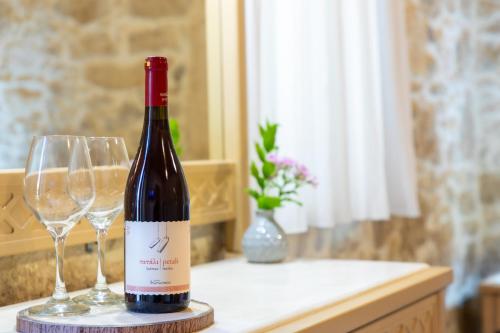 a bottle of wine and two wine glasses on a counter at Asmani in Kato Asites