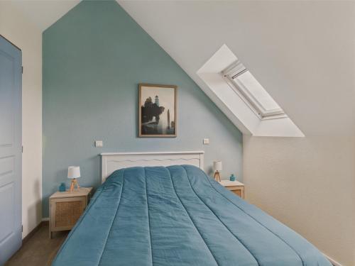 - une chambre avec un lit bleu et une lucarne dans l'établissement Balcon vue mer et piscine pour 4 personnes, à Fouesnant