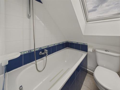 une salle de bain avec baignoire et toilettes dans l'établissement Balcon vue mer et piscine pour 4 personnes, à Fouesnant