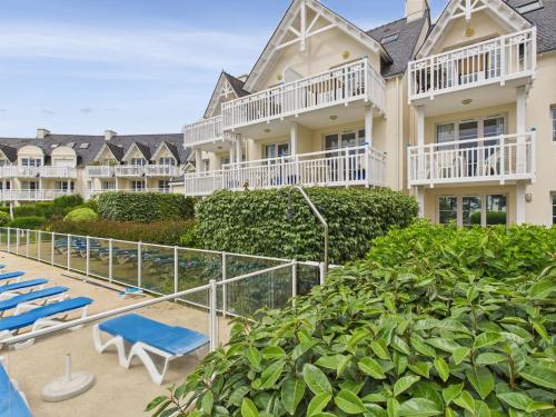 une vue d'un complexe hôtelier avec des chaises longues bleues dans l'établissement Balcon vue mer et piscine pour 4 personnes, à Fouesnant