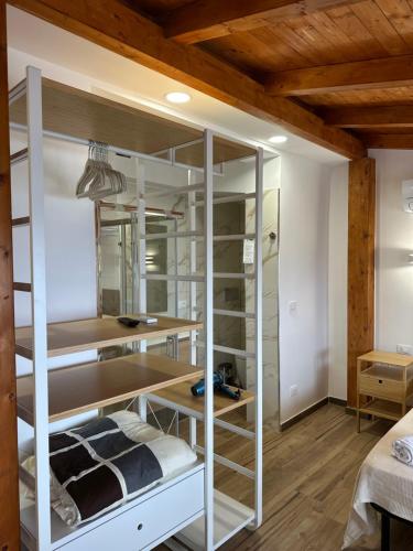 a room with white bunk beds and wooden ceilings at B&B Villa sul Mare in Melito di Porto Salvo