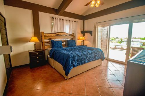 Un dormitorio con una cama con sábanas azules y un balcón. en Suite H301 @ Mara Laguna, en San Pedro