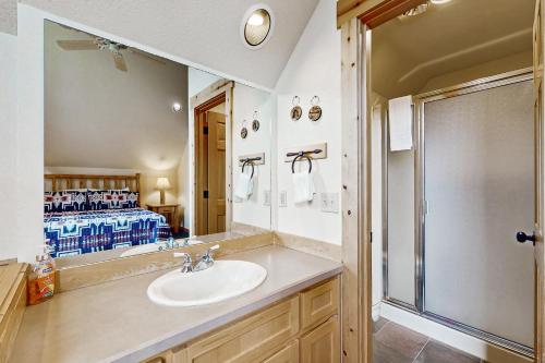 a bathroom with a sink and a shower and a bed at Eagle Crest: Prairie Falcon Retreat in Redmond