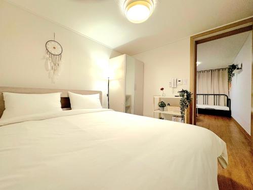 ein Schlafzimmer mit einem weißen Bett und einer Uhr an der Wand in der Unterkunft Cozy house in Seoul