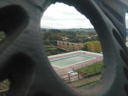 a view of a tennis court through a window at Pensión Mar in Portomarin
