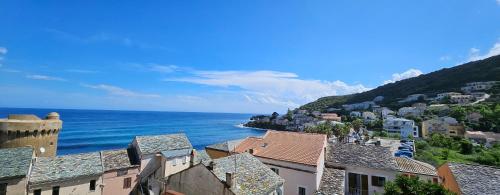 a view of a town with the ocean and buildings at Casa Sanna, T2 waterfront Miomo, Cap Corse in Santa-Maria-di-Lota