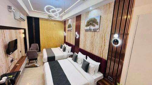 a hotel room with two beds and a television at The Shri Shyam Prime Main Har Ki Pauri Haridwar in Haridwār