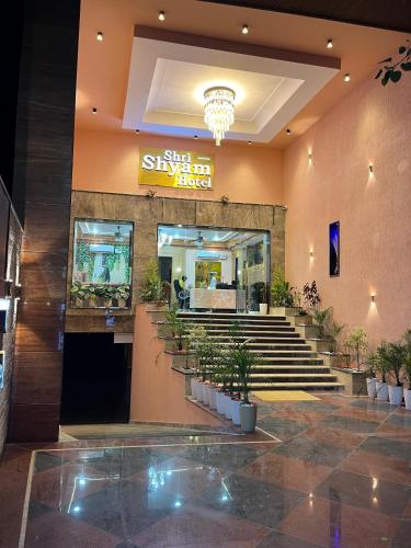 a lobby of a restaurant with stairs and potted plants at The Shri Shyam Prime Main Har Ki Pauri Haridwar in Haridwār