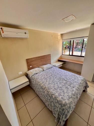 Un dormitorio pequeño con una cama y dos ventanas. en Espaço inteiro Casa de Praia no Brasil Pernambuco, en Paulista