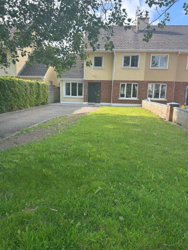 a house with a green lawn in front of it at Fab location for exploring Clare in Ennis