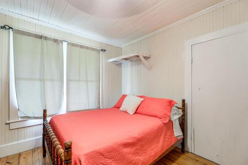 a bedroom with a bed with a red blanket and a window at 10 Mi to Cape Lookout Ferry Serene Coastal Escape in Marshallberg