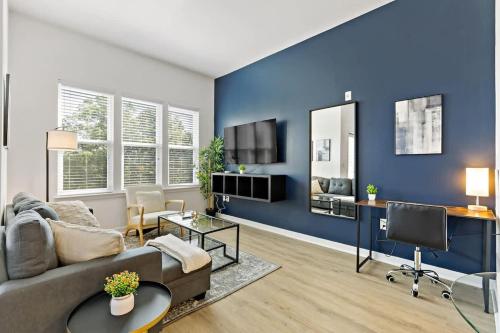 a living room with a couch and a blue wall at Chic Studio - 5 Min DT, Gym, Parking, W-D - Sleeps 6 in Charlotte
