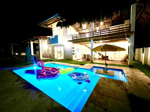 ein leerer Pool in der Nacht mit Sonnenschirm in der Unterkunft Villa Nakär - Oceanfront Luxury Villa in Playa Amatecampo, El Salvador in La Esmeralda