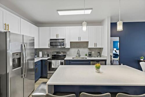a kitchen with a table and a refrigerator at Beautiful 1BD - 5Min DT, Gym, Parking, W-D - Sleeps 6 in Charlotte