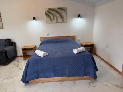 a bedroom with a blue bed with two towels at Quinta do Sossego in Pico da Pedra