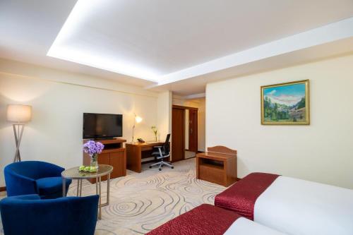a hotel room with a bed and a television at Kempinski Hotel Khan Palace in Ulaanbaatar
