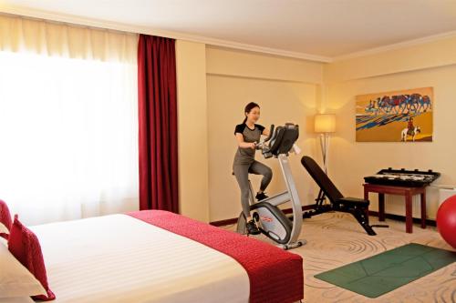 a woman exercising on a treadmill in a hotel room at Kempinski Hotel Khan Palace in Ulaanbaatar