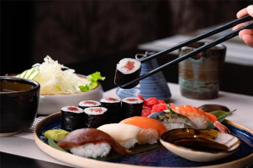 a plate with sushi and chopsticks on a table at Kempinski Hotel Khan Palace in Ulaanbaatar