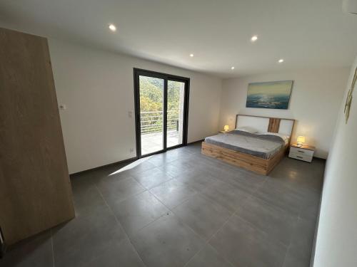 une chambre avec un lit et une grande fenêtre dans l'établissement Magnifique Villa 400m de la plage de Tarco 22 personnes, à Conca