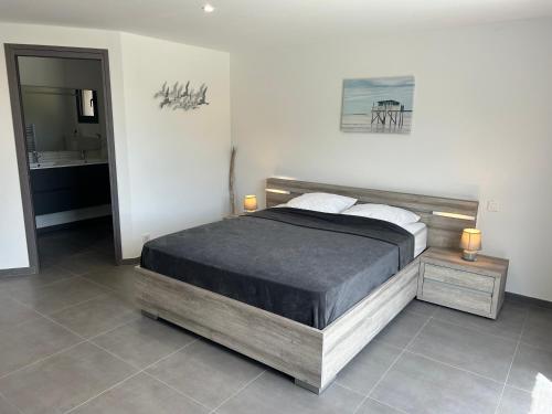 une chambre avec un grand lit et une salle de bain dans l'établissement Magnifique Villa 400m de la plage de Tarco 22 personnes, à Conca