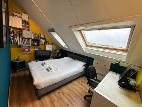 a bedroom with a bed and a desk and a window at Modern and luxury vacation house, private Jacuzzi in Zoetermeer