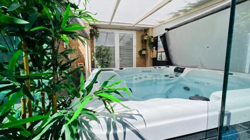 a jacuzzi tub in a room with plants at Modern and luxury vacation house, private Jacuzzi in Zoetermeer