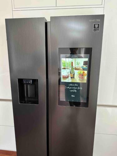 a stainless steel refrigerator with a picture of food at Modern and luxury vacation house, private Jacuzzi in Zoetermeer