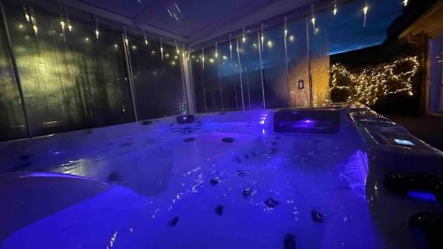a blue bath tub in a room with lights at Modern and luxury vacation house, private Jacuzzi in Zoetermeer