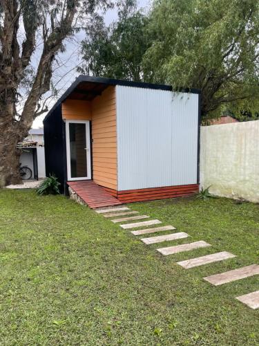 a small house with a white door and a yard at La Cabaña in Santa Clara del Mar