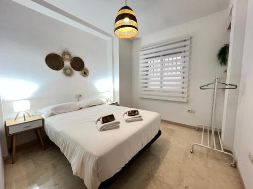 a white bedroom with a large bed and a lamp at PUSHE Peligros Business & Culture in Peligros