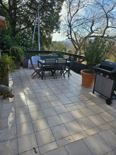 a patio with two picnic tables and a grill at La citadelle in Nyons