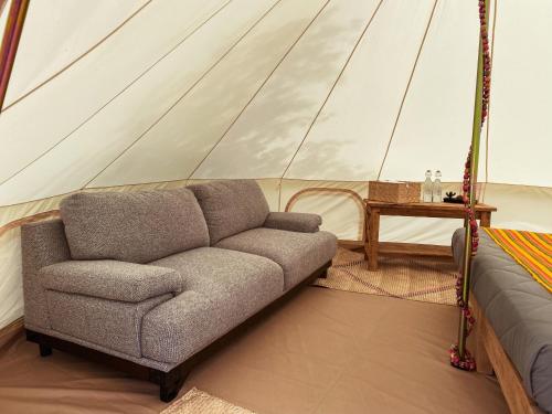 a living room with a couch in a tent at Maka Haui Glamping in San Miguel de Allende