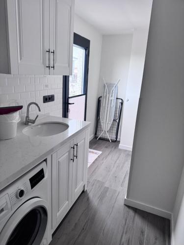 a kitchen with a sink and a washing machine at Villa Kataraktis in Seferihisar