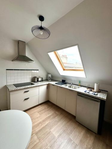 une cuisine avec une fenêtre et un évier. dans l'établissement La Petite Matelote Appartement lumineux - vue Cathédrale, à Boulogne-sur-Mer