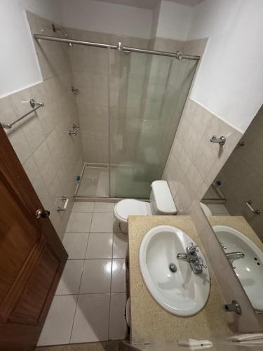 a bathroom with a sink and a shower and a toilet at Hotel Condina Pereira in Pereira