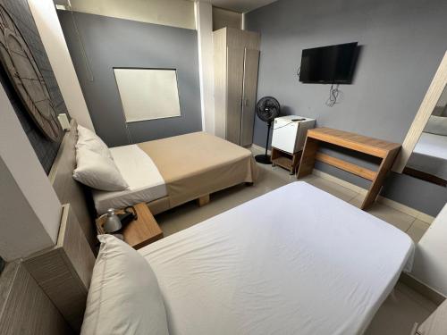 a small room with two beds and a television at Hotel Condina Pereira in Pereira