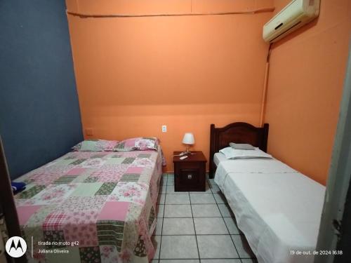 two beds in a room with orange walls at Duque HOSTEL in Belém