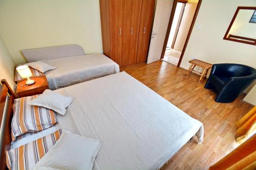 a bedroom with two beds and a desk and a chair at Apartments Soso in Kotor