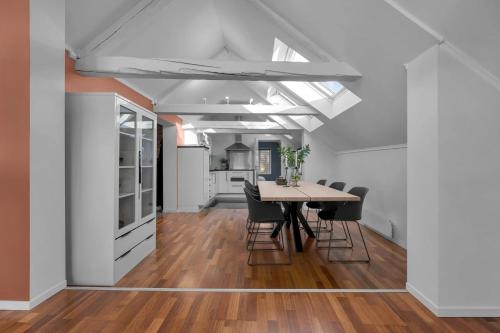 eine offene Küche und ein Esszimmer mit Tisch und Stühlen in der Unterkunft Arctic Homes - Historic Penthouse in Tromsø