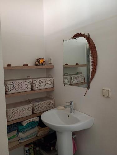 a bathroom with a sink and a mirror at Chez Laeti et Mano in Hakamui