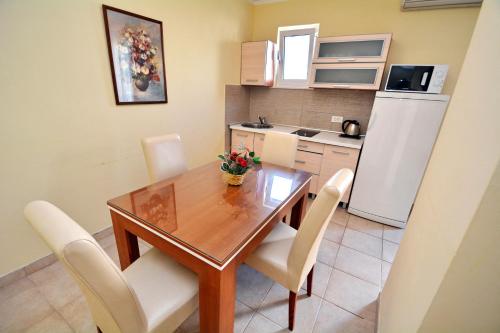 a kitchen and dining room with a wooden table and chairs at Apartments Soso in Kotor