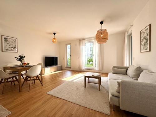 a living room with a couch and a table at HolidayHome Apartments I Airport Deluxe Condo with Terrace in Schönefeld