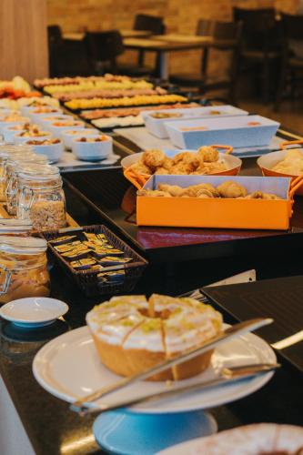 a table with many different types of food on it at Matiz Vilaboim Ribeirão Preto in Ribeirão Preto