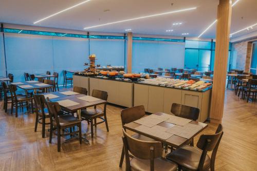 a restaurant with tables and chairs and a buffet at Matiz Vilaboim Ribeirão Preto in Ribeirão Preto