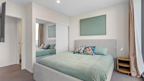 a bedroom with a bed and a couch at QV Stays Modern City Apartment in Auckland