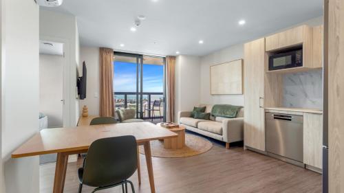 a kitchen and living room with a table and chairs at QV Stays Modern City Apartment in Auckland
